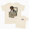 Beige t-shirt with a graphic of a dog in a cooler and 'The Wild Threads Co' 